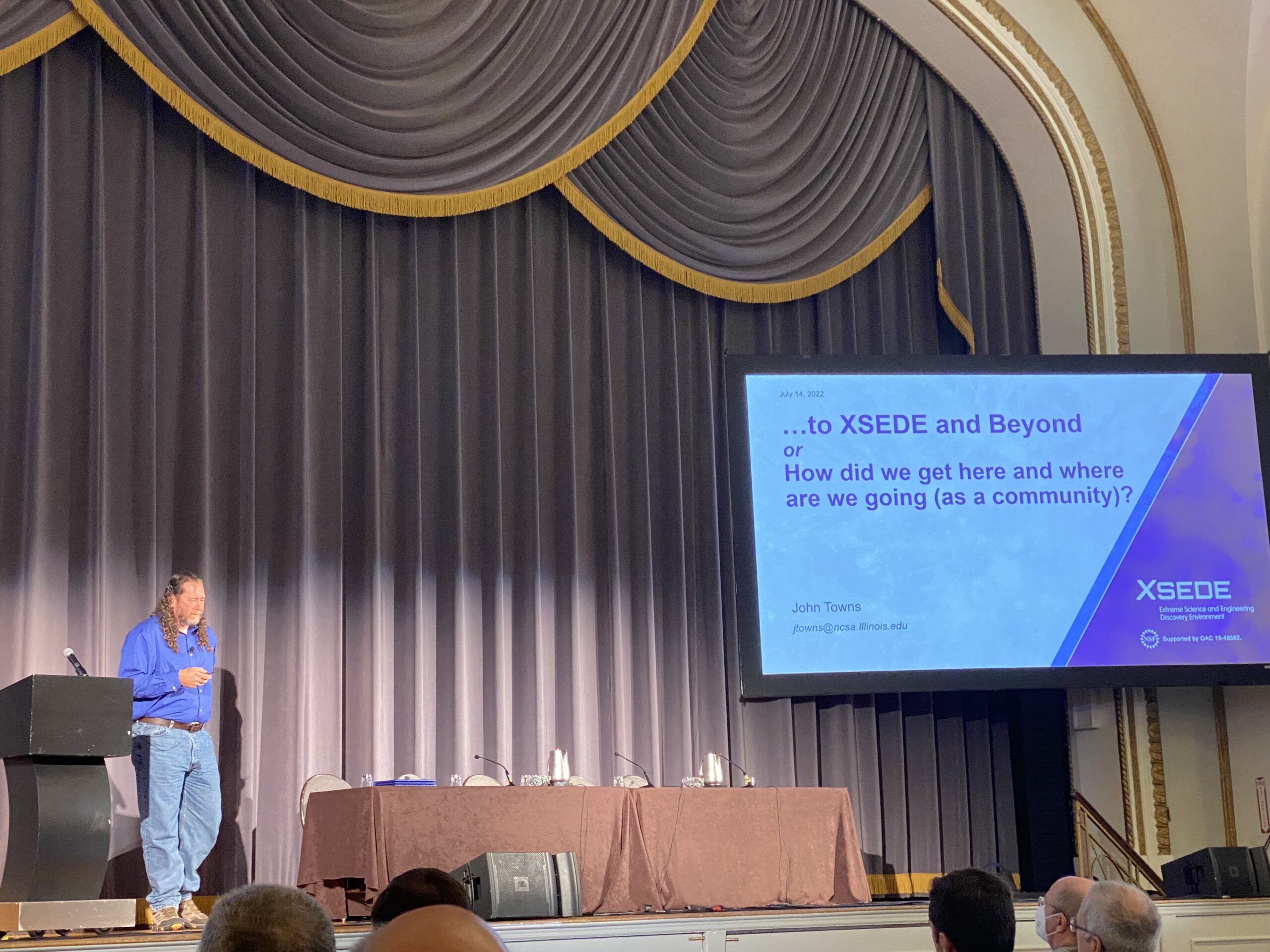 John Towns giving a speech onstage at PEARC22 conference.