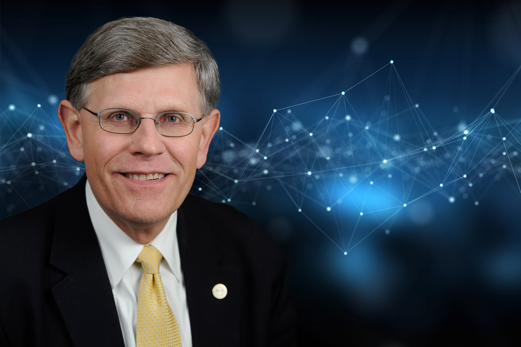 Headshot of Kelvin Droegemeier on top of a blue background image of datapoints.