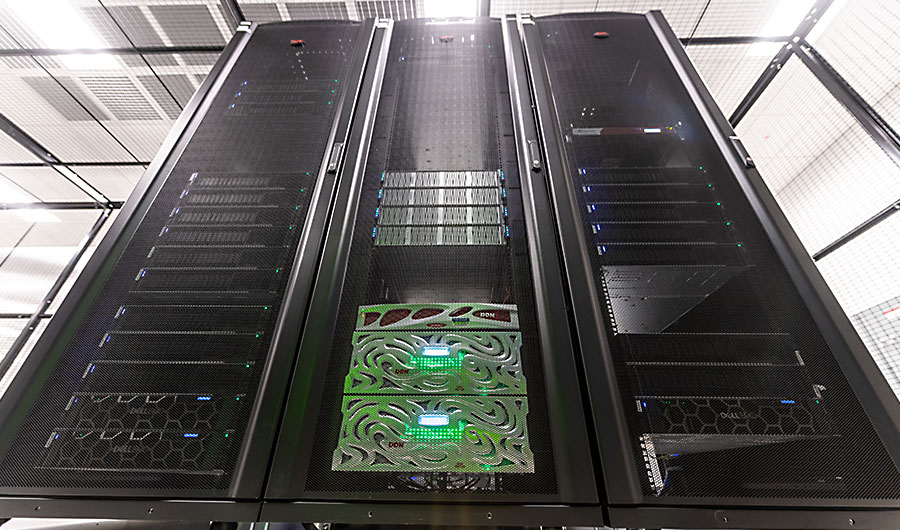 Image of the Nightingale supercomputer at NPCF, with three large towers and blinking lights