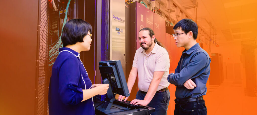 Three colleagues collaborating enthusiastically in front of a workstation at NPCF. This image is meant to convey collegiality